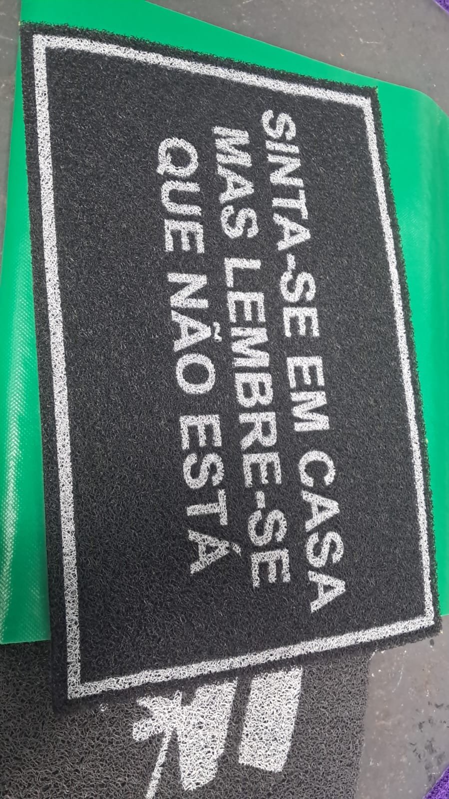 Tapete verde com recado bem-humorado de boas-vindas